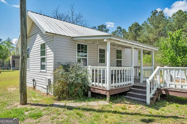 a view of house with backyard and tree