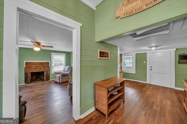 a living room with furniture flat screen tv and wooden floor