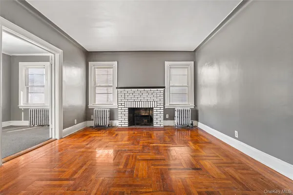 a view of an empty room with window and fire place