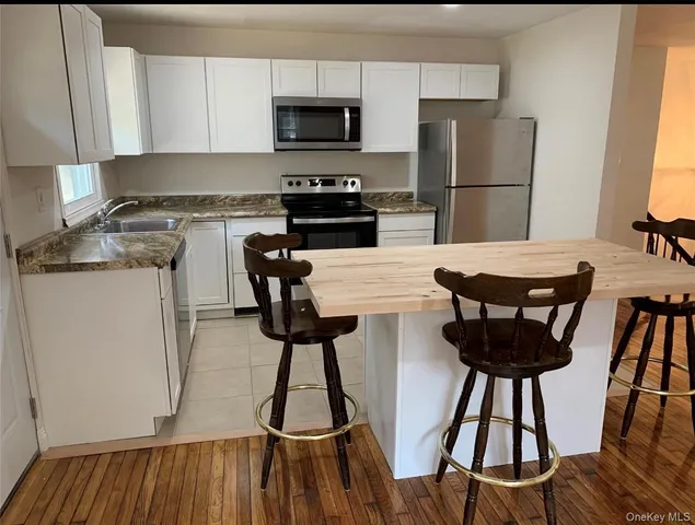 a kitchen with stainless steel appliances granite countertop a stove top oven a sink a counter space and cabinets