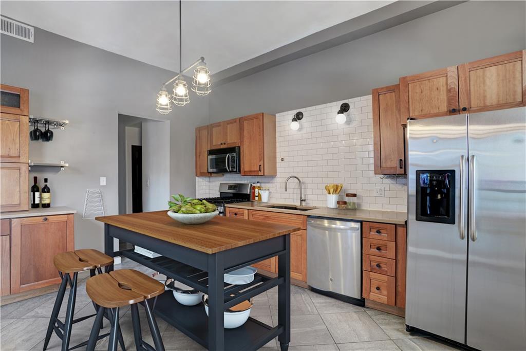 315 Main Street Pittsburgh, PA 15201 - Photo 8 of 23 a kitchen with stainless steel appliances granite countertop a table chairs sink refrigerator and microwave
