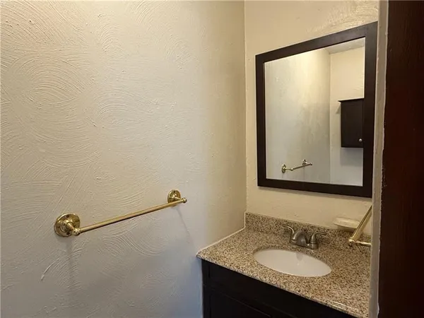a bathroom with a granite countertop sink and mirror
