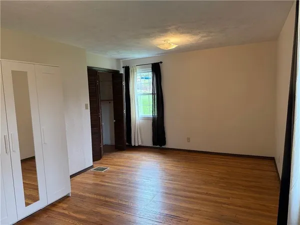 a view of an empty room with wooden floor