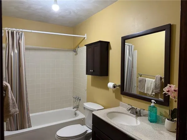 a bathroom with a granite countertop sink toilet and shower
