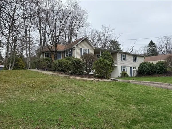 a front view of a house with a yard and trees