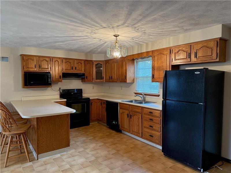 3922 Anderson Road Gibsonia, PA 15044 - Photo 8 of 23 a kitchen with stainless steel appliances granite countertop a refrigerator a sink dishwasher a stove and white countertops with wooden floor
