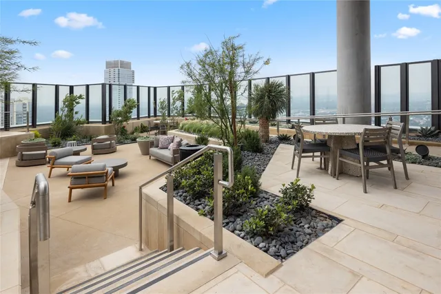 a view of a patio with couches table and chairs and potted plants