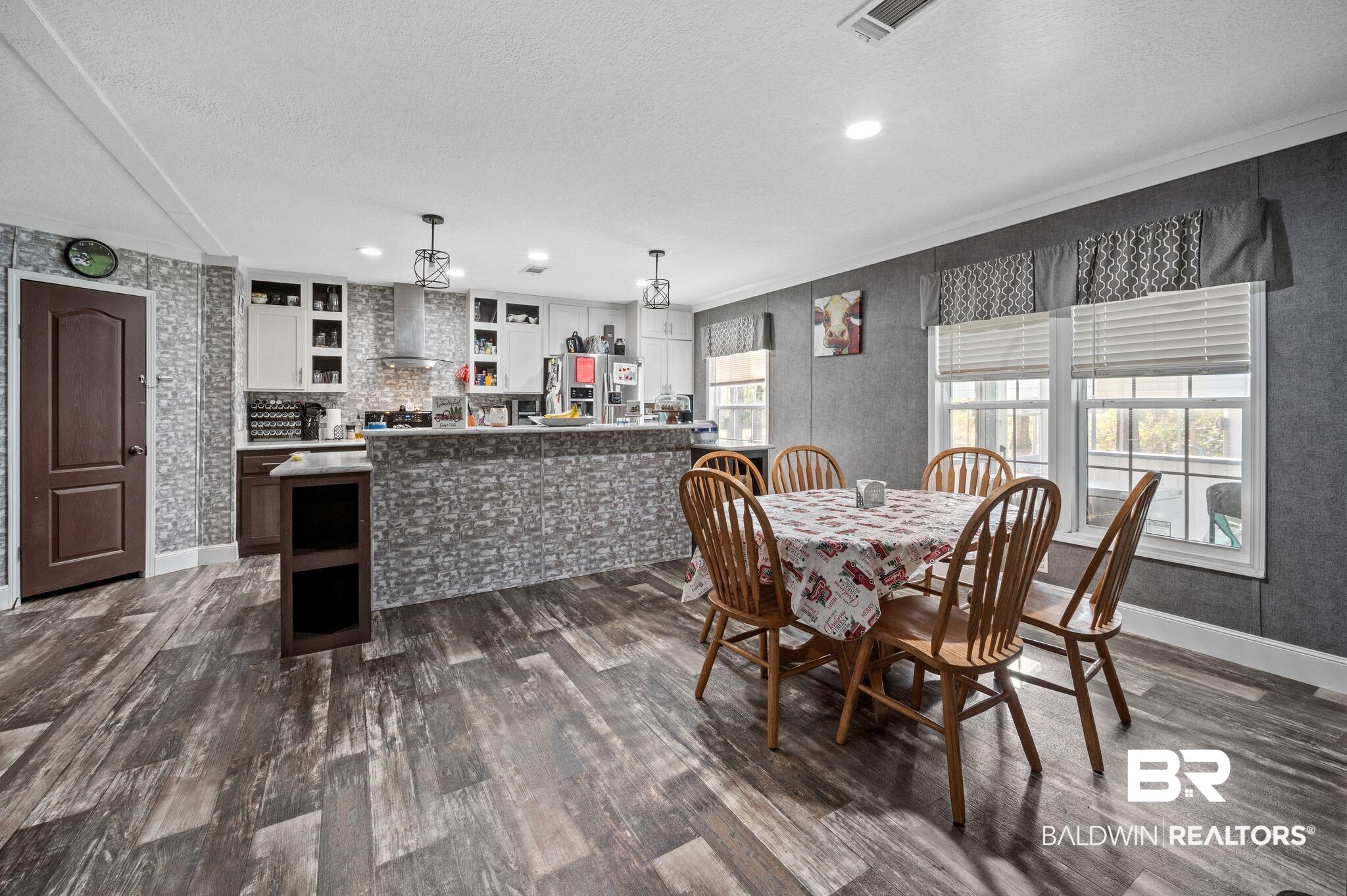 9382 D'Olive Street Bay Minette, AL 36507 - Photo 4 of 27 Dining area featuring dark hardwood / wood-style flooring, built in features, and a textured ceiling