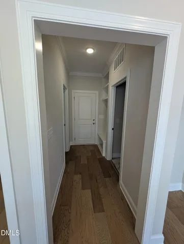 a view of a hallway with wooden floor and a hallway