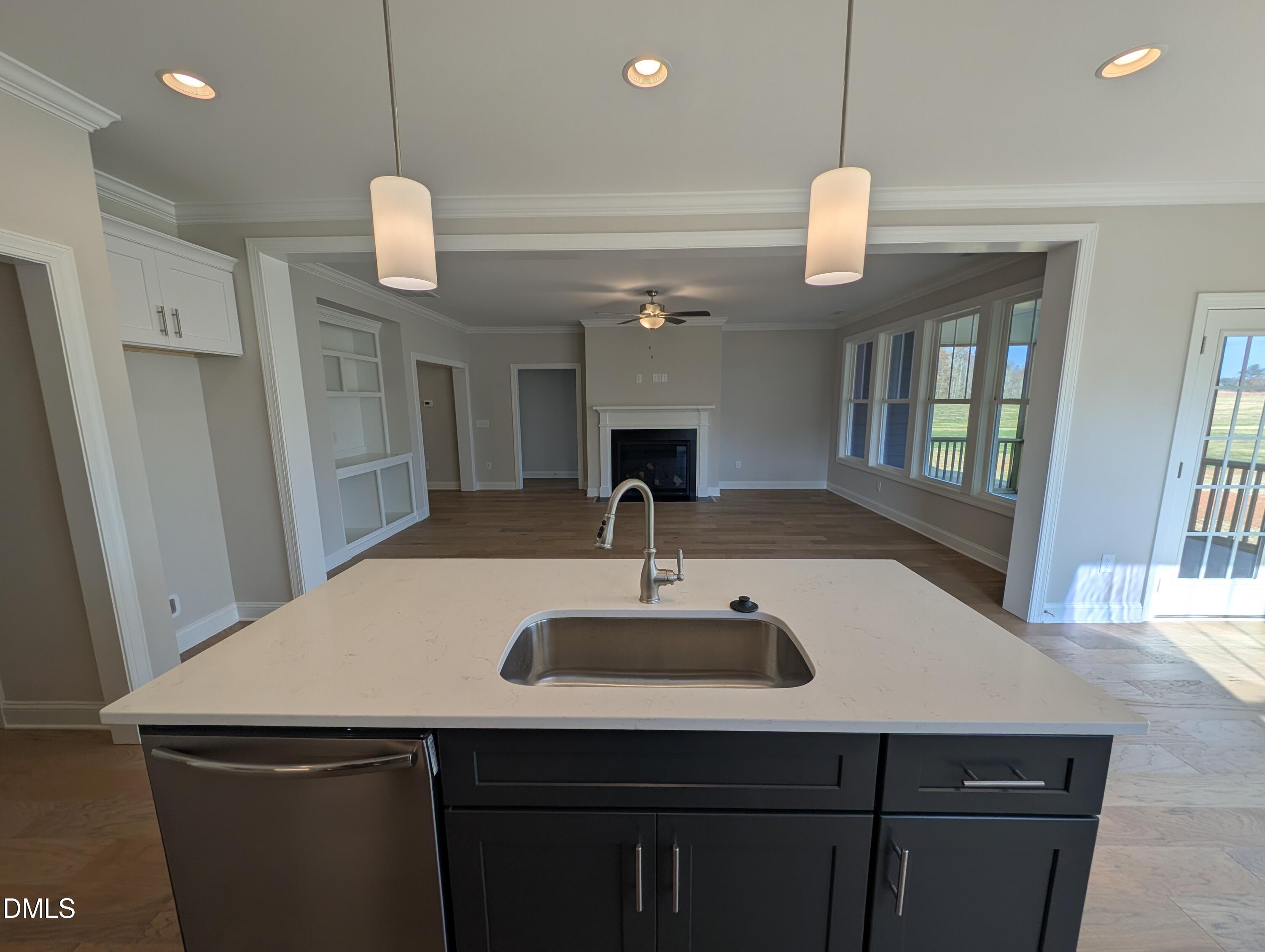 2830 John Lewis Road Burlington, NC 27217 - Photo 23 of 55 a kitchen with a sink a center island a refrigerator cabinets and living room view