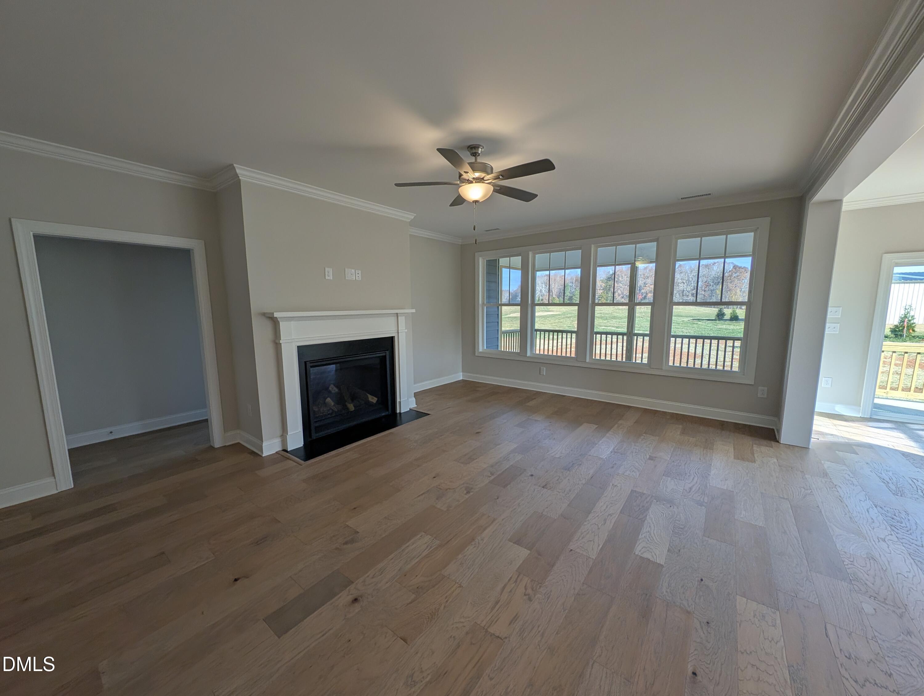 2830 John Lewis Road Burlington, NC 27217 - Photo 25 of 55 an empty room with wooden floor fireplace and windows