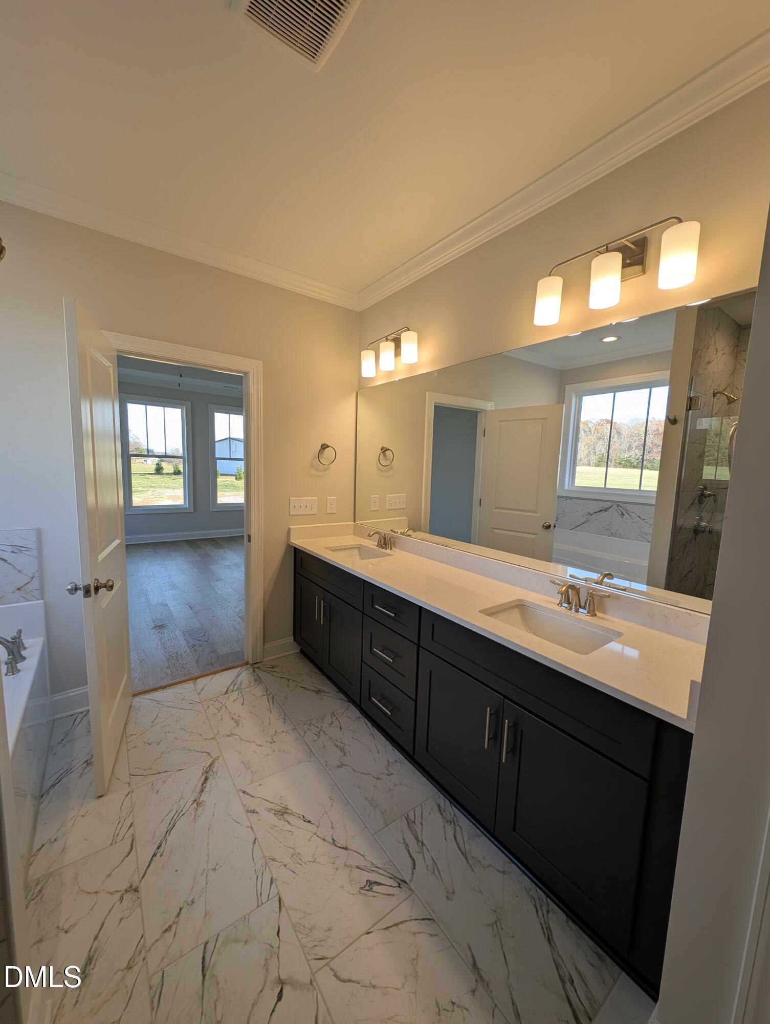 2830 John Lewis Road Burlington, NC 27217 - Photo 29 of 55 a spacious bathroom with a double vanity sink and mirror