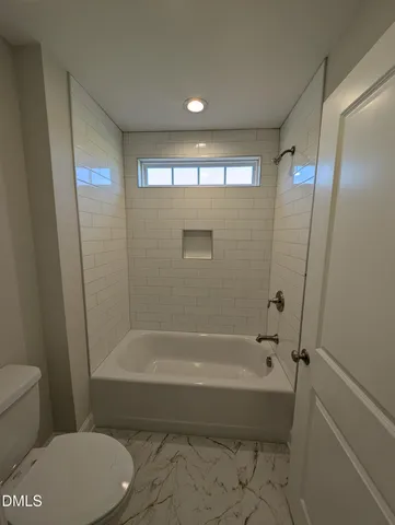 a bathroom with a bathtub and a toilet