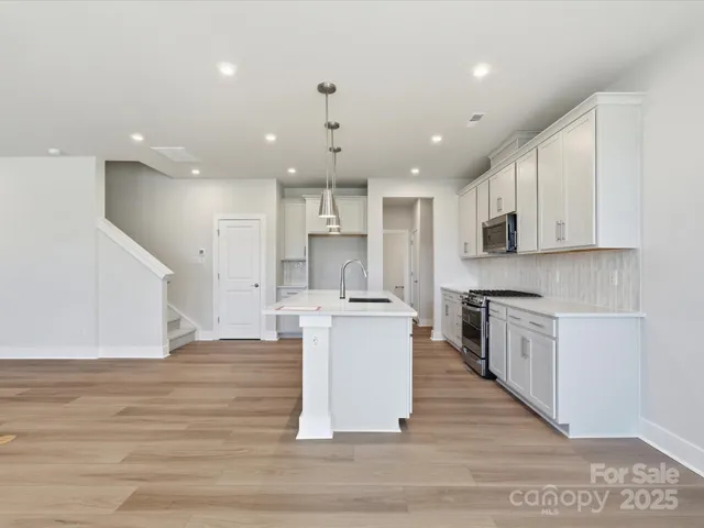 a large kitchen with kitchen island a sink a stove a center island and a window