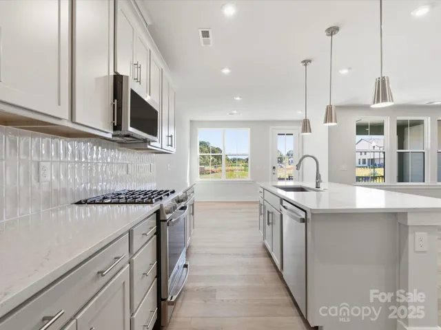 a kitchen with stainless steel appliances granite countertop a sink and stove top oven