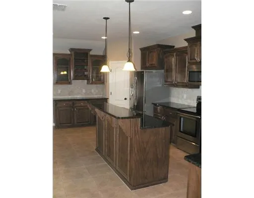 a kitchen with stainless steel appliances granite countertop a sink and a refrigerator