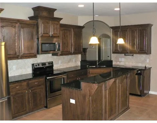 a kitchen with stainless steel appliances granite countertop a sink a stove counter space and cabinets