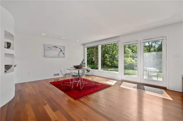 a living room with a table window and wooden floor