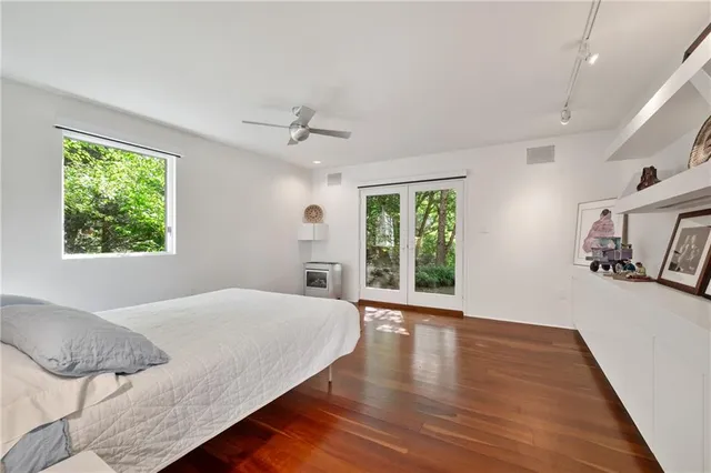 a bedroom with a large bed wooden floor and window