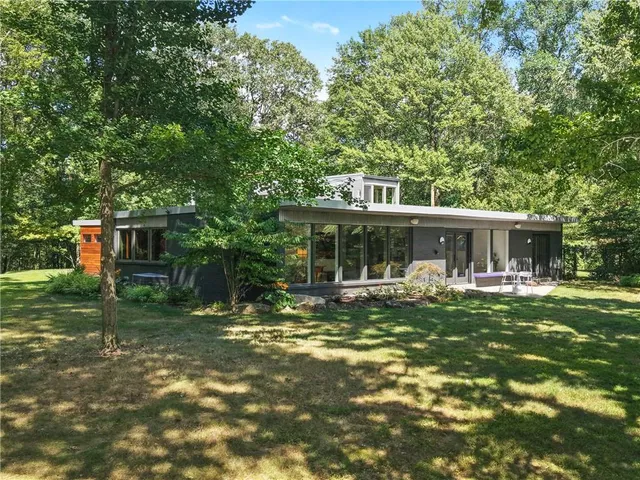 a front view of house with yard barbeque and outdoor seating