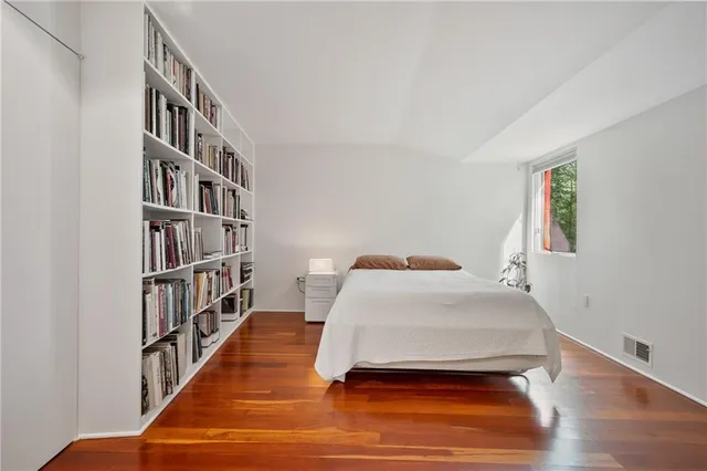 a bedroom with a bed and a book shelf