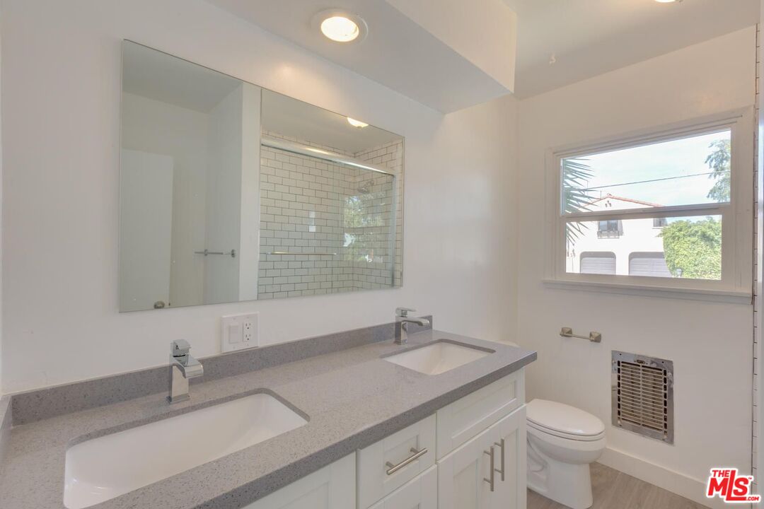 4179 Ince Boulevard, Unit 1/2 Culver City, CA 90232 - Photo 14 of 15 a bathroom with a granite countertop sink a toilet and a mirror