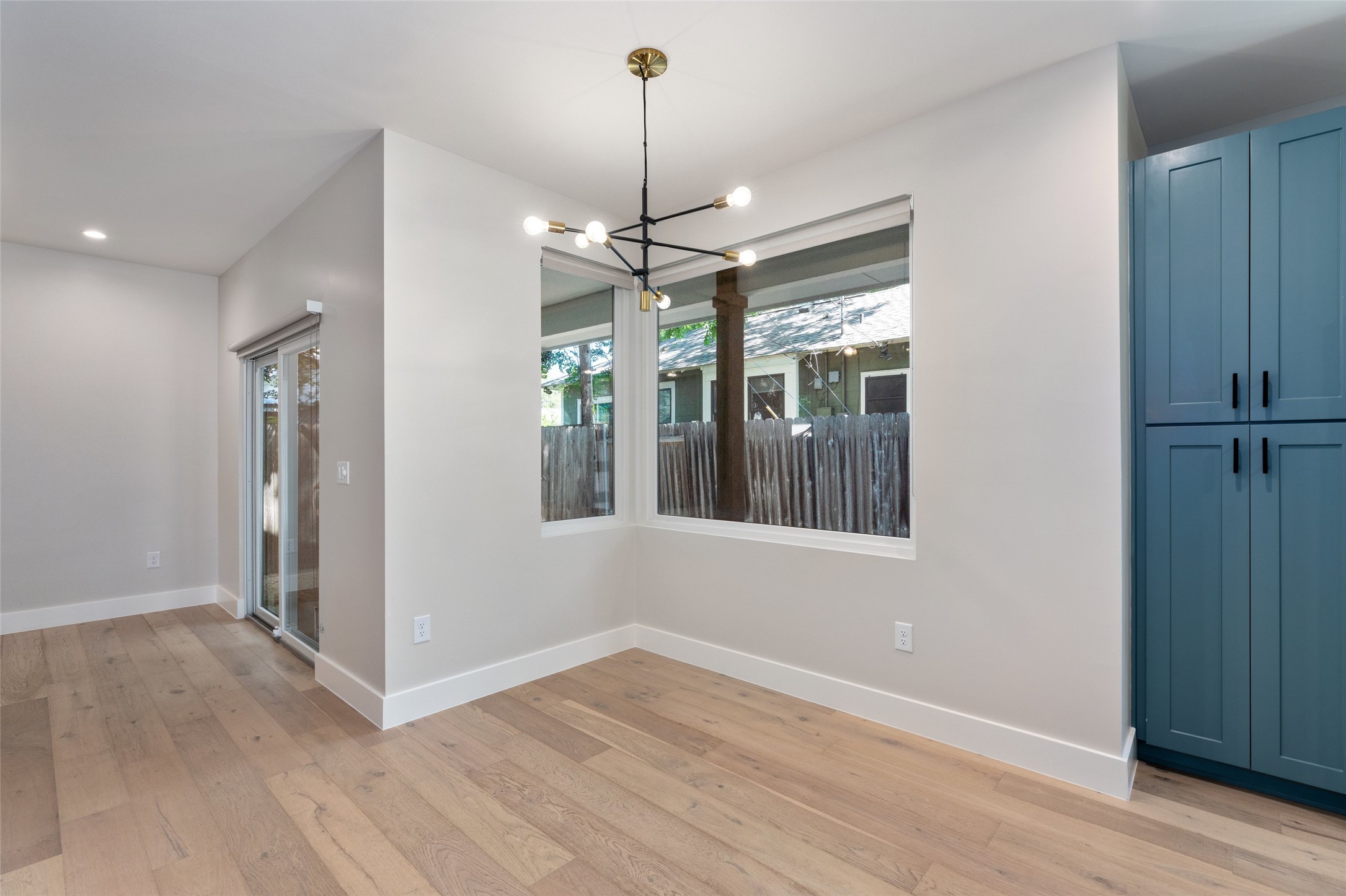 5200 Grover Avenue Austin, TX 78756 - Photo 9 of 32 Dining area off of the kitchen with an abundance of light and view to the outdoors. Modern light fixture compliments the dining area. Light hardwood finish flooring complements white walls and trim.