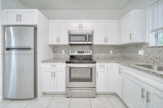 a kitchen with white cabinets and white appliances