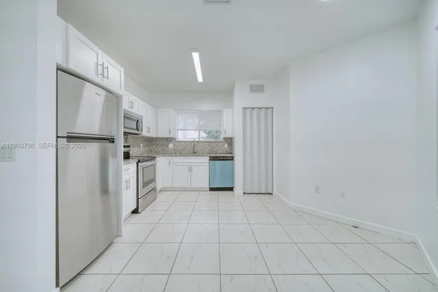 a kitchen with a sink a refrigerator and cabinets
