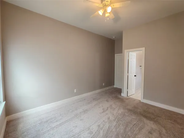 a view of an empty room with a chandelier fan
