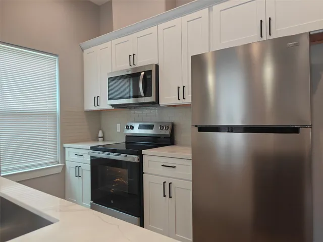 a kitchen with stainless steel appliances a refrigerator sink and microwave