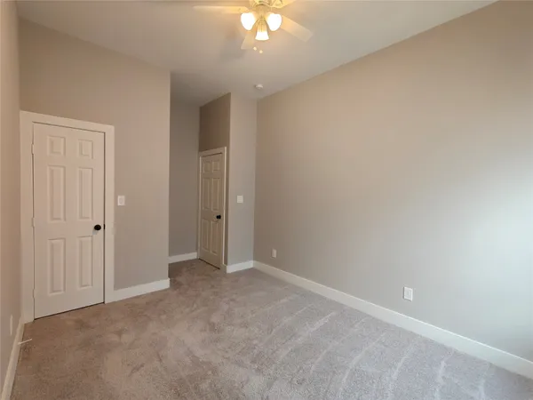 a view of an empty room with a chandelier fan