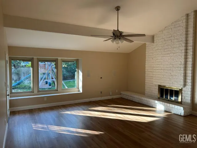 a view of empty room with wooden floor and fireplace