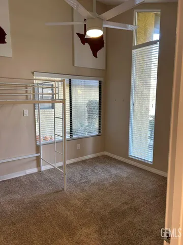 an empty room with fan and windows