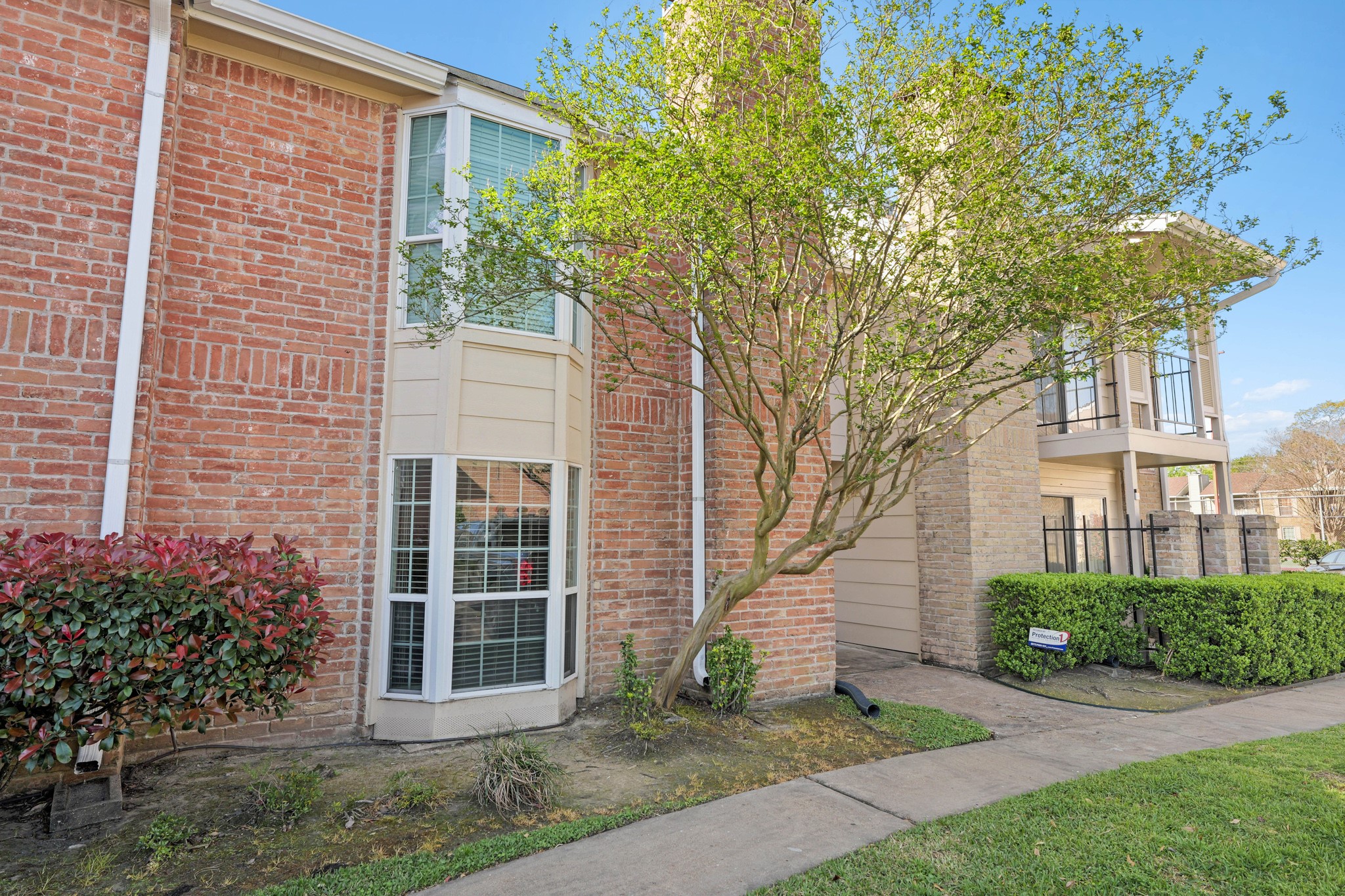 2800 Jeanetta Street, Unit 1402 Houston, TX 77063 - Photo 1 of 29 a view of a brick house with a large windows plants and large trees