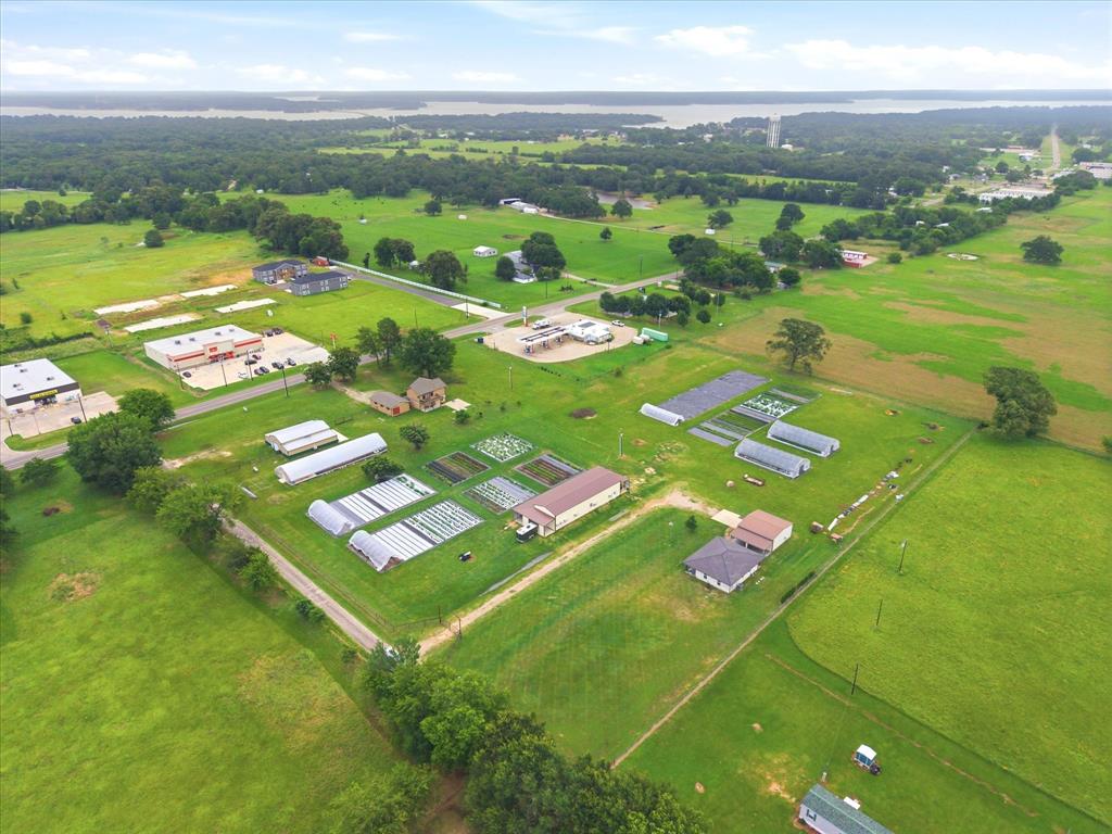 4020 Farm To Market 515 Emory, TX 75440 - Photo 27 of 39 The full picture — 7.695 surveyed acres with greenhouses, caterpillar tunnels, irrigated row crops, dual road frontage, and both residences visible from above. Lake Fork on the horizon, the town of Emory at your doorstep. Everything is here