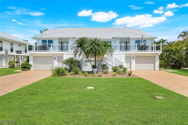 a front view of a house with a yard and palm tree
