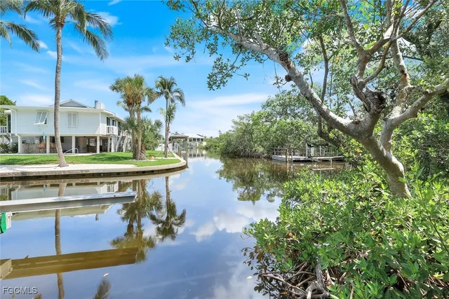 a view of a lake with a bench and trees around