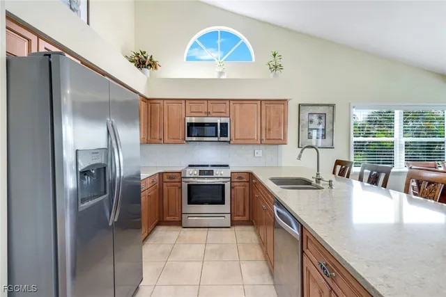a kitchen with stainless steel appliances granite countertop a sink a stove and a refrigerator
