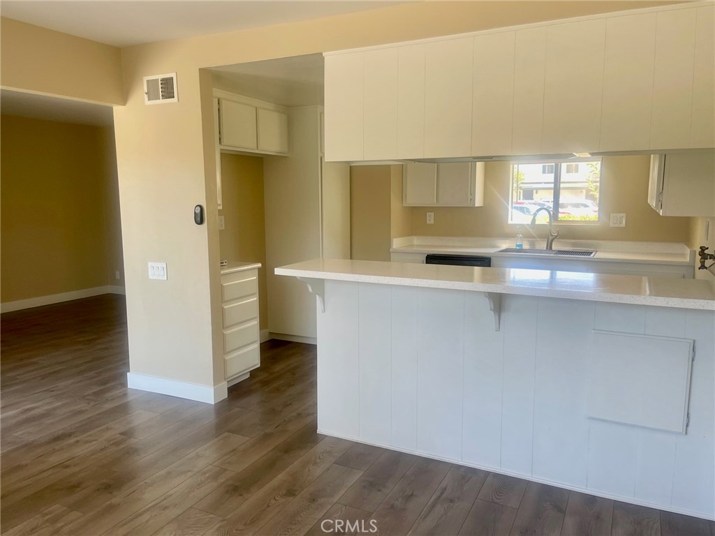 2447 Elden Avenue, Unit C2 Costa Mesa, CA 92627 - Photo 4 of 10 a kitchen with stainless steel appliances granite countertop a sink and wooden cabinets