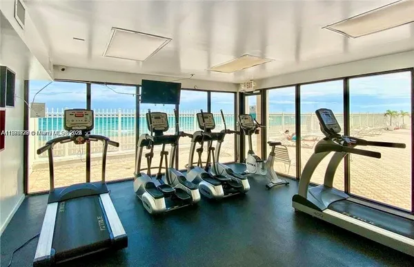 a room with gym equipment and large mirror