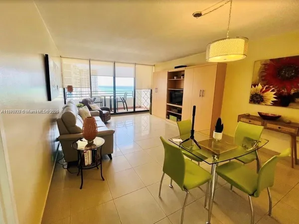 a living room with patio furniture and a floor to ceiling window