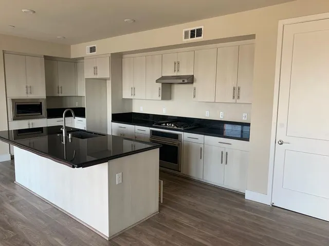 a kitchen with granite countertop a sink and cabinets