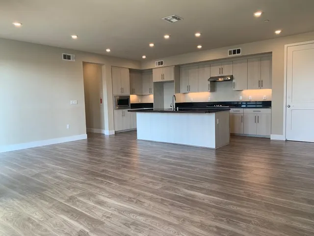 a kitchen with stainless steel appliances granite countertop a stove a sink and a refrigerator