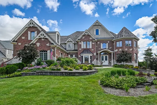 a front view of a house with a yard and potted plants
