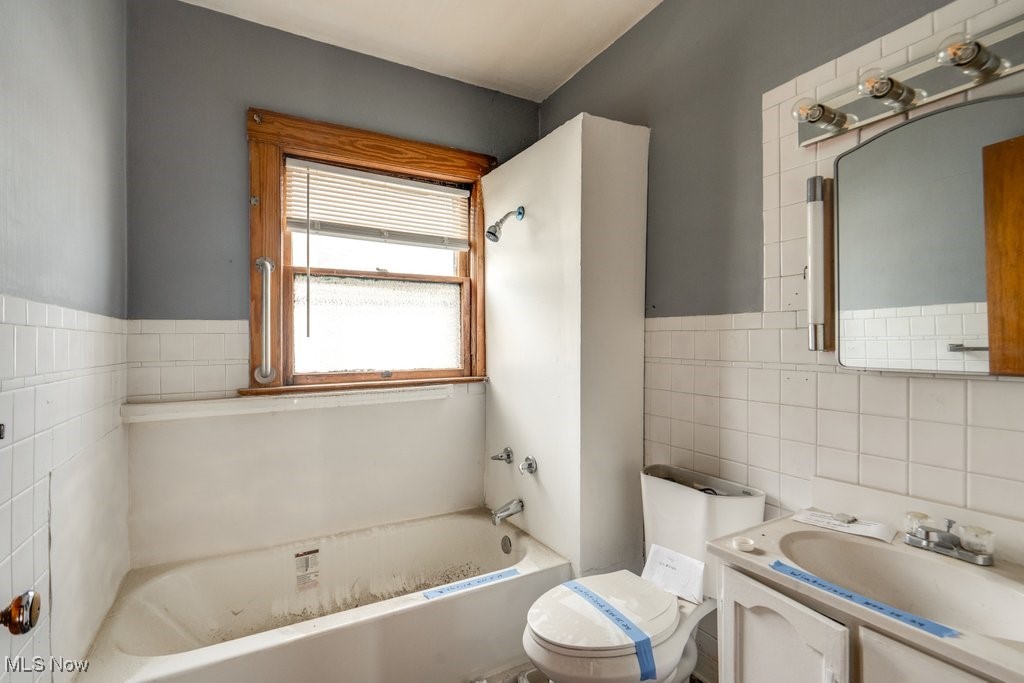 13702 Rugby Road Cleveland, OH 44110 - Photo 17 of 22 Bathroom featuring vanity, tile walls, and toilet