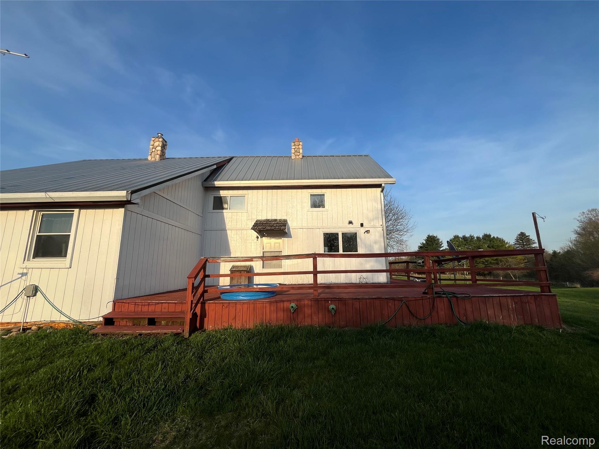 4218 Babcock Road, Unit 3 Croswell, MI 48422 - Photo 12 of 42 Rear view of property featuring a deck, a lawn, a metal roof, and a chimney
