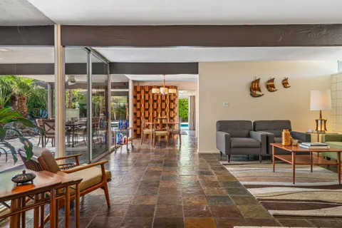 a view of a dining room with furniture wooden floor and garden view