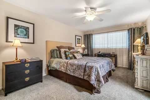 a view of a patio with table and chairs potted plants and floor to ceiling window