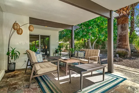 a view of a patio with a table chairs and a fire pit